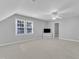 Bonus room with neutral carpet, ceiling fan, and a bright window overlooking the backyard at 2125 Oakcrest Ct, Raleigh, NC 27612