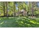 View of a brick home with lush green lawn, mature trees and landscaping at 2125 Oakcrest Ct, Raleigh, NC 27612