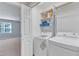 Bright laundry room with modern washer and dryer set and practical shelving space at 2125 Oakcrest Ct, Raleigh, NC 27612
