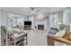 Spacious living room with a white fireplace, ceiling fan, and light wood floors at 2125 Oakcrest Ct, Raleigh, NC 27612