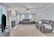 Open concept living room with fireplace, ceiling fan, and light wood floors at 2125 Oakcrest Ct, Raleigh, NC 27612