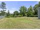 Expansive backyard with lush greenery, mature trees, and partial fencing for added privacy at 218 Mason Rd, Durham, NC 27712