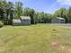 Spacious backyard with lush green grass, surrounded by mature trees and a partial fence at 218 Mason Rd, Durham, NC 27712