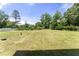 Large, well-maintained backyard with lush green grass and mature trees for privacy at 218 Mason Rd, Durham, NC 27712