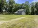 Large backyard with green grass and trees, showcasing the home's rear exterior and yard space at 218 Mason Rd, Durham, NC 27712
