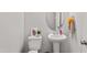 Bathroom featuring a pedestal sink, toilet, oval mirror, and tasteful decor accents at 218 Mason Rd, Durham, NC 27712