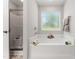 A bright bathroom with a soaking tub, a separate shower, and a large window at 218 Mason Rd, Durham, NC 27712