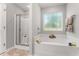 A bright bathroom with a soaking tub, a separate shower, and a large window at 218 Mason Rd, Durham, NC 27712