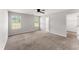 A bedroom with carpet, a ceiling fan, two windows, and access to a closet and the ensuite bathroom at 218 Mason Rd, Durham, NC 27712