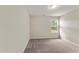 This bedroom offers neutral walls, plush carpeting, and a window letting in natural light at 218 Mason Rd, Durham, NC 27712