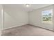 Bright, carpeted bedroom featuring a large window with natural light and neutral wall paint at 218 Mason Rd, Durham, NC 27712
