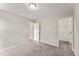 Neutral-toned carpeted bedroom with a walk-in closet and natural light entering from the doorway at 218 Mason Rd, Durham, NC 27712