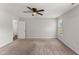 View of a bedroom highlighting its neutral walls, ceiling fan, and natural light from the windows at 218 Mason Rd, Durham, NC 27712