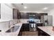 Modern kitchen with stainless steel appliances, granite countertops, tile backsplash, and dark wood cabinets at 218 Mason Rd, Durham, NC 27712