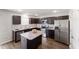 A full kitchen featuring stainless steel appliances, a marble countertop island, and dark wood cabinetry at 218 Mason Rd, Durham, NC 27712