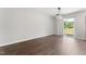 An open floor plan living room with dark wood floors, access to a sliding door, and a modern chandelier at 218 Mason Rd, Durham, NC 27712