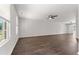 Spacious living area with wood floors, offering natural light from large windows and a ceiling fan at 218 Mason Rd, Durham, NC 27712
