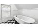 Bright bathroom featuring a standalone tub, black and white tile flooring, and a sunlit window at 2202 St Marys St, Raleigh, NC 27608