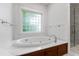 Relaxing bathroom features a large soaking tub with marble deck and tiled accents at 2202 St Marys St, Raleigh, NC 27608