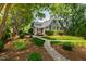 Landscaped front yard with brick pathway leading to charming two-story home at 2202 St Marys St, Raleigh, NC 27608