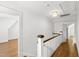 Bright hallway featuring hardwood floors, a white banister, and access to other rooms at 2202 St Marys St, Raleigh, NC 27608