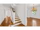 Open staircase features hardwood floors and a chandelier in the adjoining room at 2202 St Marys St, Raleigh, NC 27608