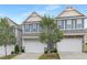 Two-story townhomes featuring a two-car garage, gray siding, blue shutters, and landscaped front yards at 222 Explorer Dr # 271, Morrisville, NC 27560