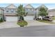 View of three townhomes with two-car garages, gray siding, and blue shutters, showcasing a well-kept street at 222 Explorer Dr # 271, Morrisville, NC 27560
