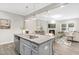 Open-concept kitchen with gray cabinets, granite countertops, an island with sink, and a view into the cozy living room at 222 Explorer Dr # 271, Morrisville, NC 27560