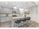 Bright kitchen with gray cabinets, granite countertops, a central island with bar seating, and modern pendant lighting at 222 Explorer Dr # 271, Morrisville, NC 27560
