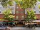Inviting building entrance with street-side dining and lush greenery creates a welcoming atmosphere for residents and visitors at 222 Glenwood Ave # 714, Raleigh, NC 27603