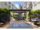 Community patio with outdoor seating under a pergola with hanging lights at 222 Glenwood Ave # 714, Raleigh, NC 27603