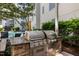 Outdoor built-in barbecue grill and dining area with pool in the background at 222 Glenwood Ave # 714, Raleigh, NC 27603