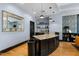 Stylish wet bar area with dark cabinetry and light countertops under modern pendant lighting at 222 Glenwood Ave # 714, Raleigh, NC 27603