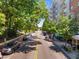 Beautiful street scene with lush green trees, parked cars, and building in the background at 222 Glenwood Ave # 714, Raleigh, NC 27603