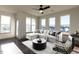 Living room area with hardwood floors, large windows and light-colored furniture at 2328 Gathering Sq Ct, Fuquay Varina, NC 27526