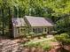 Traditional home featuring a brick chimney, light gray siding, black shutters, and manicured landscaping at 24 Sunrise Pl, Durham, NC 27705