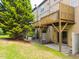 Townhouse backyard with green grass, a large tree and wooden patios that have access to the yard at 2609 Stewart Pines Dr, Raleigh, NC 27615