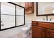 Well-lit bathroom featuring a shower with black trim, toilet, wood cabinets and updated countertops at 2609 Stewart Pines Dr, Raleigh, NC 27615