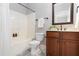 Well-lit bathroom featuring a shower and a wooden vanity with a mirror and neutral decor at 2609 Stewart Pines Dr, Raleigh, NC 27615