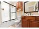 This bathroom features wood cabinets and drawers, a wide mirror, and a shower over tub at 2609 Stewart Pines Dr, Raleigh, NC 27615