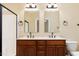Bathroom features a double vanity with dark wood cabinets, framed mirrors and shower with glass door at 2609 Stewart Pines Dr, Raleigh, NC 27615