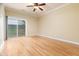Bright bedroom featuring hardwood floors, a ceiling fan, and a sliding glass door that opens to the outside at 2609 Stewart Pines Dr, Raleigh, NC 27615