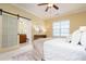 Comfortable bedroom with ensuite bath, sliding barn door, ceiling fan, and plush rug, making it welcoming at 2609 Stewart Pines Dr, Raleigh, NC 27615
