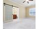 Bedroom with a sliding glass door leading to bathroom, beige walls and plush carpeting at 2609 Stewart Pines Dr, Raleigh, NC 27615