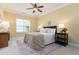 Bright bedroom with a queen-size bed, ceiling fan, and carpet, creating a cozy and inviting atmosphere at 2609 Stewart Pines Dr, Raleigh, NC 27615