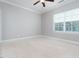 Neutral bedroom features a window with blinds, neutral walls, plush carpeting and ceiling fan at 2609 Stewart Pines Dr, Raleigh, NC 27615