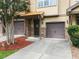 A townhome with a brown garage door, stone accents, and a landscaped front yard, offering curb appeal at 2609 Stewart Pines Dr, Raleigh, NC 27615
