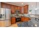 Modern kitchen features stainless steel appliances, granite counters, and cherry wood cabinets with recessed lighting at 2609 Stewart Pines Dr, Raleigh, NC 27615