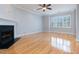 Spacious living room with hardwood floors, fireplace, and a large window with shutter style blinds at 2609 Stewart Pines Dr, Raleigh, NC 27615